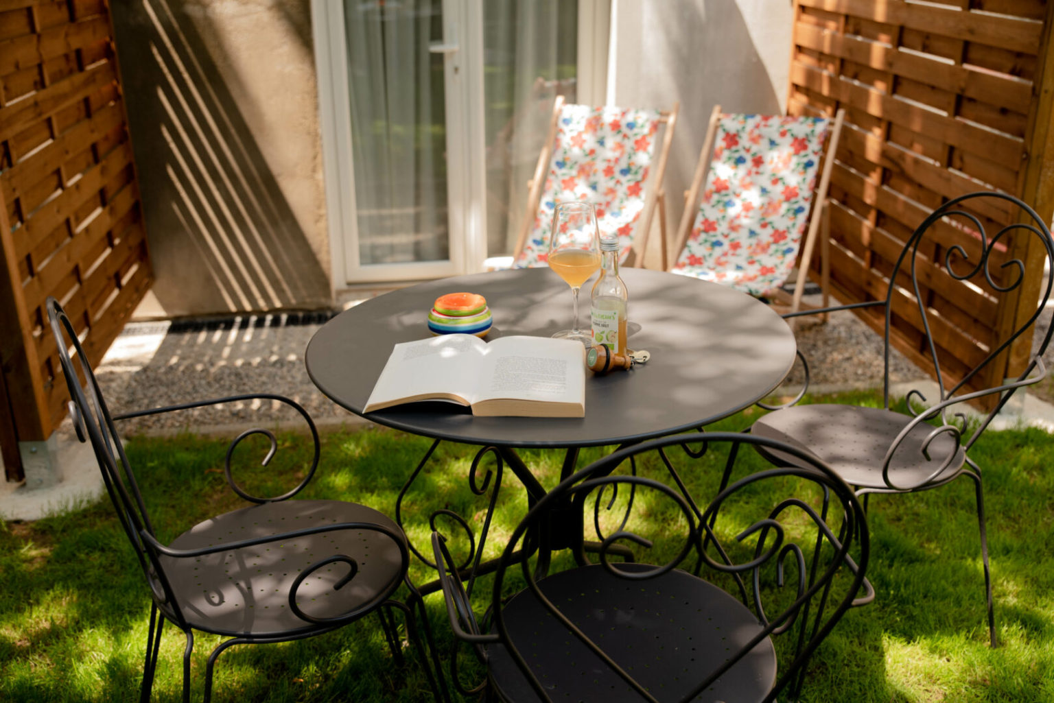 Terrasse privative d'une chambre rez-de-jardin, table et chaises en fer forg&eacute;