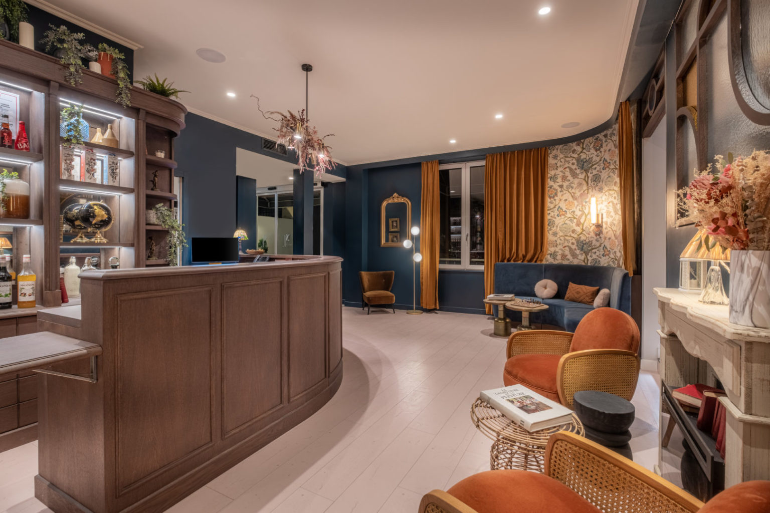 Lobby avec r&eacute;ception, chemin&eacute;e et fauteuils en velours orange