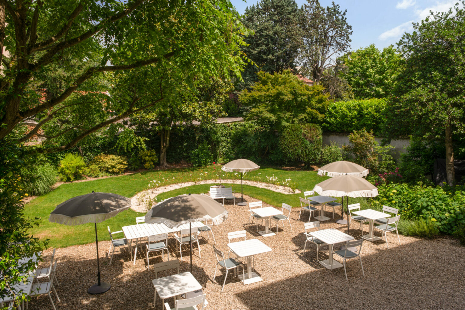 Terrasse ombrag&eacute;e du jardin avec tables et parasols