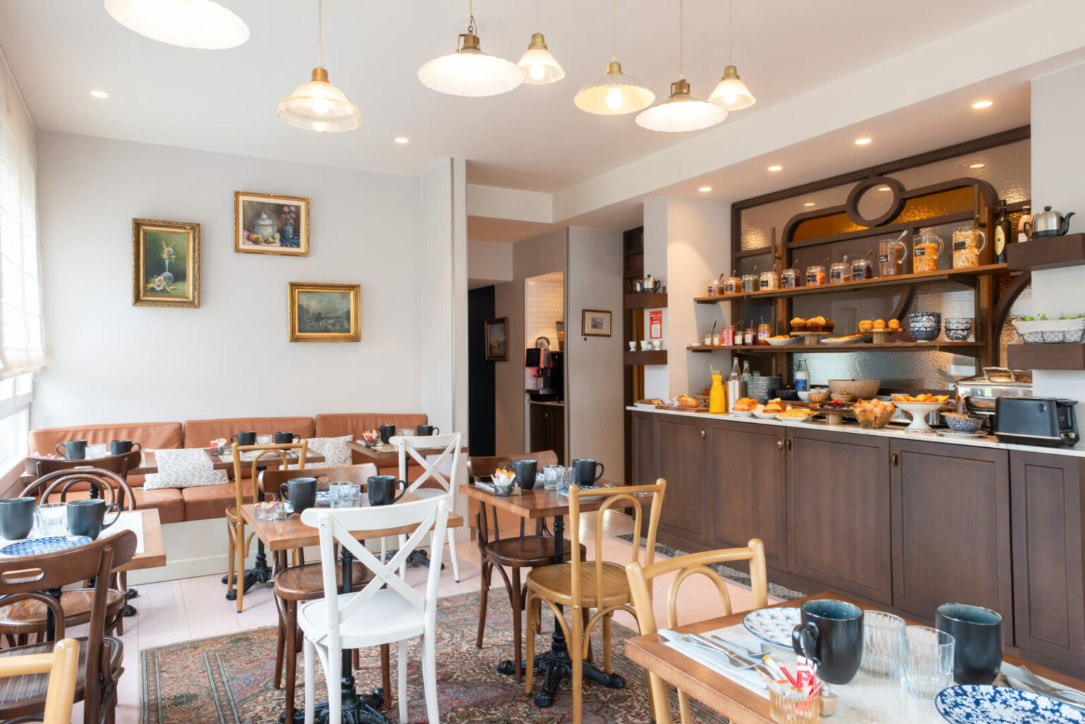 Salle du petit-d&eacute;jeuner avec buffet et tables en bois